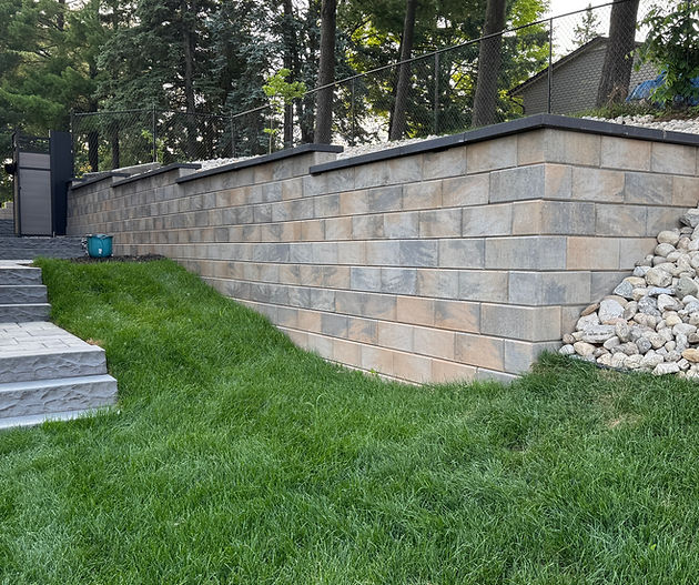 Precast retaining wall beside a lawn and stone stairway